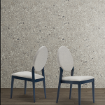 Thumbnail of http://Deux%20chaises%20modernes%20aux%20cadres%20bleus%20et%20aux%20coussins%20gris%20clair%20sont%20placées%20côte%20à%20côte%20sur%20un%20plancher%20en%20bois.%20Un%20mur%20en%20pierre%20grise%20texturée%20sert%20de%20toile%20de%20fond,%20créant%20un%20décor%20minimaliste%20et%20contemporain.